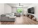Cozy living room with gray sectional, large picture window, and modern entertainment center at 30273 Marquette Ave, Wesley Chapel, FL 33545