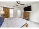 Main bedroom features stylish sliding barn door and rustic wood dresser with mounted tv at 30273 Marquette Ave, Wesley Chapel, FL 33545