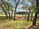 Picturesque backyard with mature trees providing shade and privacy, complemented by a screened-in porch at 3181 Deltona Blvd, Spring Hill, FL 34606