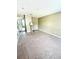Spacious bedroom with neutral walls and carpet, light fixture, and doorway to hallway at 3181 Deltona Blvd, Spring Hill, FL 34606
