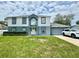 Inviting two-story home featuring a well-manicured lawn and attached two car garage at 3181 Deltona Blvd, Spring Hill, FL 34606