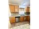 Kitchen featuring granite counters, stainless appliances, wood cabinets, and tile backsplash at 3181 Deltona Blvd, Spring Hill, FL 34606