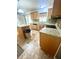 Kitchen featuring wood cabinets, stainless appliances, an island, and tile flooring at 3181 Deltona Blvd, Spring Hill, FL 34606