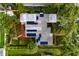 Aerial view of a home with solar panels surrounded by lush greenery and brick pathways at 3321 14Th N St, St Petersburg, FL 33704