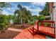 Picturesque backyard with a red deck, mature landscaping, and a peaceful garden path at 3321 14Th N St, St Petersburg, FL 33704