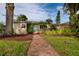Charming single-story home featuring a stone facade and vibrant turquoise door, set amidst a lush, landscaped front yard at 3321 14Th N St, St Petersburg, FL 33704