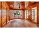Inviting living room with natural wood walls, ceiling fan, and ample natural light from doors at 3321 14Th N St, St Petersburg, FL 33704