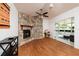 Living room featuring a stone fireplace, a ceiling fan, and doors that connect to a sunroom at 3321 14Th N St, St Petersburg, FL 33704