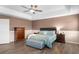 Comfortable bedroom features a dark wood bed frame, ceiling fan, and neutral decor at 3351 Lintower Dr, Land O Lakes, FL 34638