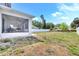 Backyard view with a screened porch, featuring ceiling fans, and a white fence surrounding the property at 3602 W Iowa Ave, Tampa, FL 33611