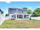 Backyard view of the home featuring a screened in patio and white fencing at 3602 W Iowa Ave, Tampa, FL 33611