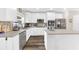 Spacious kitchen featuring white cabinetry, stainless steel appliances, and center island with sink at 3602 W Iowa Ave, Tampa, FL 33611