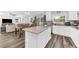 Open-concept kitchen and dining area featuring stainless appliances, center island and hardwood flooring at 3602 W Iowa Ave, Tampa, FL 33611