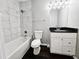 Bathroom featuring tiled shower-tub, sleek fixtures, vanity and dark hardwood floors at 3615 W Cherry St, Tampa, FL 33607