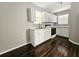 Bright kitchen with white cabinets, modern appliances, and stylish dark hardwood floors at 3615 W Cherry St, Tampa, FL 33607