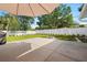 Landscaped backyard features a concrete patio, small fire pit, and a pristine white fence for privacy at 4208 W Bay Vista Ave, Tampa, FL 33611