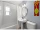 Bathroom features a classic pedestal sink, tub with shower, and a window for natural light at 4208 W Bay Vista Ave, Tampa, FL 33611