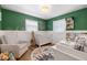 Charming Bedroom with green accent wall, board and batten, playful decor, and a cozy rocking chair at 4208 W Bay Vista Ave, Tampa, FL 33611