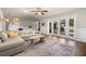 Cozy living room with a comfortable sectional sofa, hardwood floors, and sliding glass doors leading to the outdoors at 4208 W Bay Vista Ave, Tampa, FL 33611