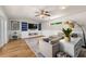 Bright living room with hardwood floors, a ceiling fan, and a custom-built entertainment center with blue accents at 4208 W Bay Vista Ave, Tampa, FL 33611