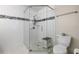 This modern shower has white tiled walls, black accent tile, and corner shelving at 4208 W Bay Vista Ave, Tampa, FL 33611
