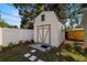 Exterior view of storage shed with double doors and quaint window, complemented by lush landscaping at 4208 W Bay Vista Ave, Tampa, FL 33611