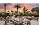 A cozy outdoor fire pit area with seating, landscaping, and a colorful sunset, perfect for evening gatherings at 4286 Cairoli Ct, Wesley Chapel, FL 33543