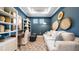 Cozy living room with stylish decor, including a comfortable sofa, patterned rug, and bright blue walls at 4286 Cairoli Ct, Wesley Chapel, FL 33543