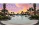 A stunning pool with palm trees and a colorful sunset providing a luxurious and relaxing atmosphere at 4286 Cairoli Ct, Wesley Chapel, FL 33543