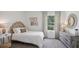 Cozy bedroom featuring a bed, rattan accents, a window with patterned curtains, and neutral decor at 4381 Sand Dollar Way, Zephyrhills, FL 33541
