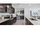Modern kitchen features stainless appliances, a center island with seating and plenty of countertop space at 4381 Sand Dollar Way, Zephyrhills, FL 33541