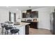 Modern kitchen features an island with counter seating, dark cabinets and stainless steel appliances at 4381 Sand Dollar Way, Zephyrhills, FL 33541