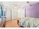 Bright bedroom with white accents, features wood floors and a pop of color with a purple accent wall at 4801 71St N St, St Petersburg, FL 33709