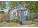 Charming blue home featuring a red door, white trim, and a well-maintained front yard at 4801 71St N St, St Petersburg, FL 33709