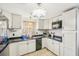 Cozy kitchen featuring white cabinets, dark countertops, tile flooring and an overhead lighting fixture at 4801 71St N St, St Petersburg, FL 33709