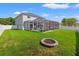Expansive backyard featuring a screened-in pool and spa, complemented by a cozy fire pit area at 4805 Holdsworth Dr, Land O Lakes, FL 34639