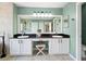 Elegant bathroom with dual sinks, black countertops, and a large mirror with modern lighting at 4805 Holdsworth Dr, Land O Lakes, FL 34639