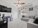 Spacious bedroom with comfortable seating area, wall mounted television, and ceiling fan at 4805 Holdsworth Dr, Land O Lakes, FL 34639