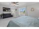 Bright bedroom with a view, featuring a TV, ceiling fan, and a comfortable bed at 4805 Holdsworth Dr, Land O Lakes, FL 34639