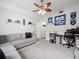 Neutral bedroom with plush carpet, ceiling fan, sports memorabilia, and comfortable seating area at 4805 Holdsworth Dr, Land O Lakes, FL 34639
