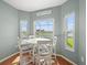 Bright breakfast nook features a round table, four chairs, and a view of the screened-in patio and canal at 4805 Holdsworth Dr, Land O Lakes, FL 34639