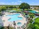 The aerial view of the community pool features a hot tub, splash pad and ample lounge seating at 4805 Holdsworth Dr, Land O Lakes, FL 34639
