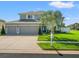 Two-story home featuring a well-manicured lawn, and three-car garage, on corner lot at 4805 Holdsworth Dr, Land O Lakes, FL 34639