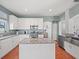 Kitchen with white cabinetry, granite counters, stainless appliances, and a center island at 4805 Holdsworth Dr, Land O Lakes, FL 34639