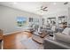 Open-concept living room with hardwood floors, large windows, and comfortable seating at 4805 Holdsworth Dr, Land O Lakes, FL 34639