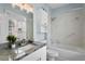 Bright bathroom featuring a granite vanity top, modern fixtures, and marble-tiled shower and tub at 501 Knights Run Ave # 5103, Tampa, FL 33602