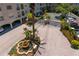 Aerial of gated entrance featuring mature palm trees, lush landscaping, and a decorative fountain at 501 Knights Run Ave # 5103, Tampa, FL 33602