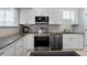 Modern kitchen features stainless steel appliances, light granite countertops and white cabinetry at 501 Knights Run Ave # 5103, Tampa, FL 33602
