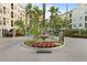 Circular water fountain surrounded by colorful flowers and tropical plants in a landscaped roundabout at 501 Knights Run Ave # 5103, Tampa, FL 33602