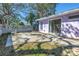 The backyard shows a concrete patio with room for outdoor furniture and privacy wall with a lilac colored house at 5010 109Th N Way, St Petersburg, FL 33708